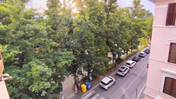Eine von Bäumen gesäumte Straße mit parkenden Autos.
