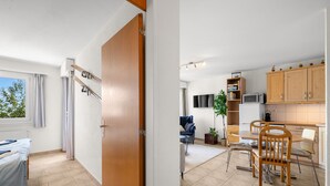 Un espace de vie compact comprenant un coin cuisine, un espace repas et un lit.