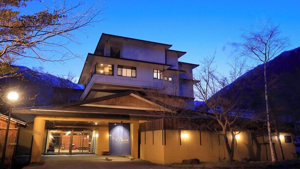A multi-story building with a traditional architectural style, featuring a prominent entrance with a wooden overhang.