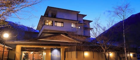 A multi-story building with a traditional architectural style, featuring a prominent entrance with a wooden overhang.