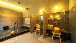 A modern bathroom with a sauna, a mirror, and wooden stools. - Super Hotel Tokushima Komatsushima Natural Hot Spring (Komatsushima)