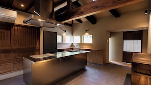 Una cocina moderna con una isla central, electrodomésticos integrados y techo de madera.