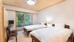 A hotel room with two beds, a TV, a desk, and a chair. - Hanazono Onsen Kaho no Sato (Katsuragi)