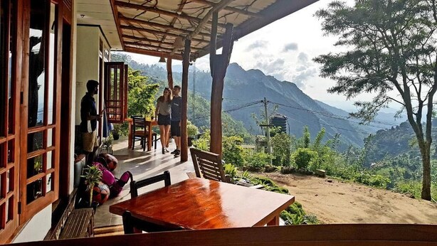 Un área de estar al aire libre, cubierta, con vista a las montañas.