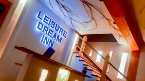 Una escalera que conduce a una habitación con un letrero que dice 'Leisure Dream Inn'.