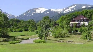 Un edificio con un cartel que dice 'POLE POL' en un paisaje verde con una montaña al fondo.