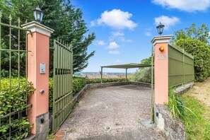 Un cancello con un cartello numerico, un lampione e una vista del paesaggio.