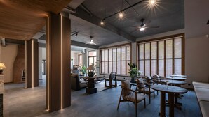 A spacious indoor area with high ceilings, exposed ductwork, and large windows. - Benjue Rushi Guesthouse Taoxichuan (Jingdezhen)