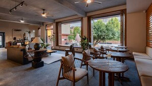 A modern interior with ceiling fans, large windows, and a mix of seating areas.
