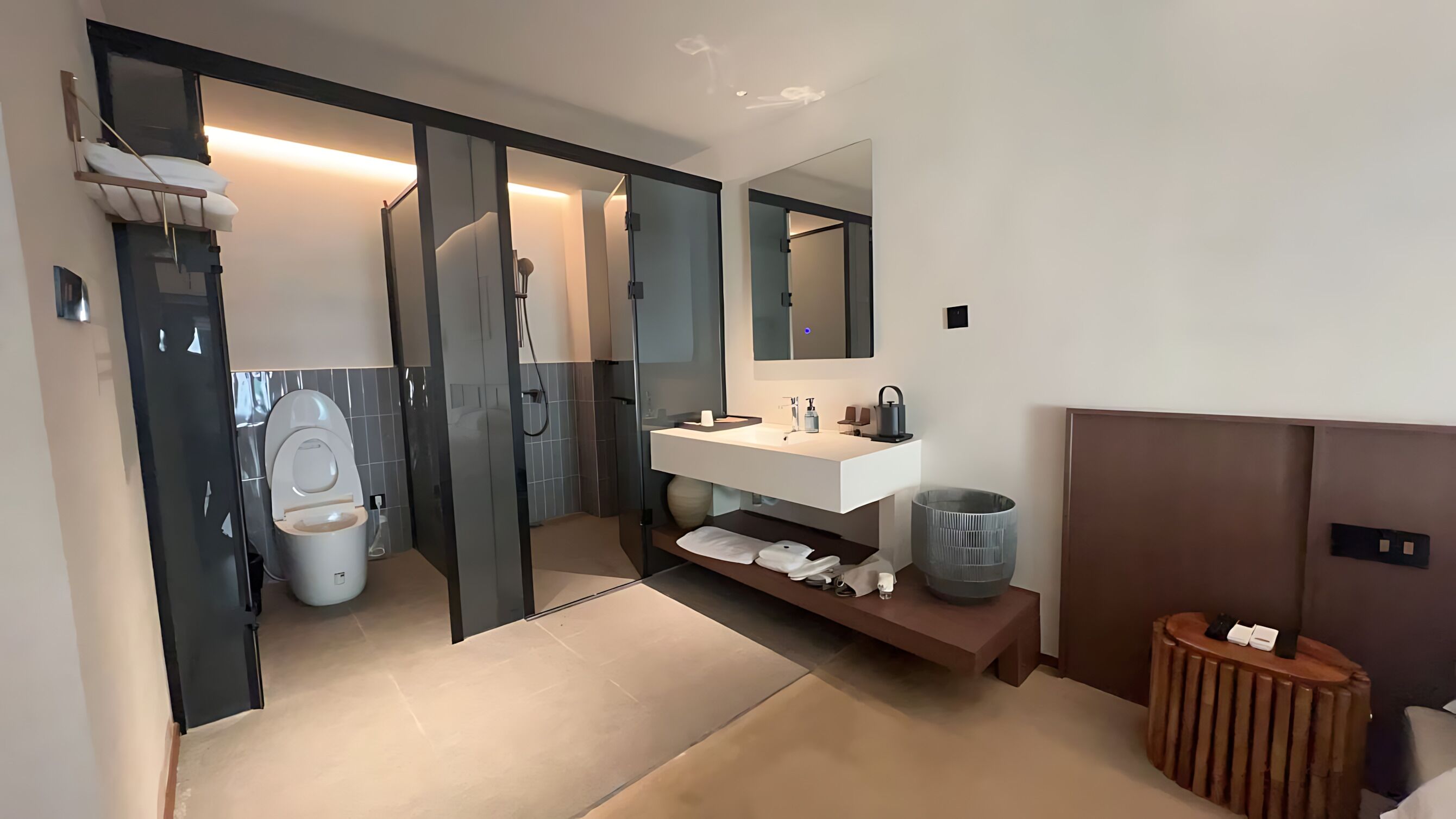 Un baño moderno con inodoro, ducha, tocador y espejo.