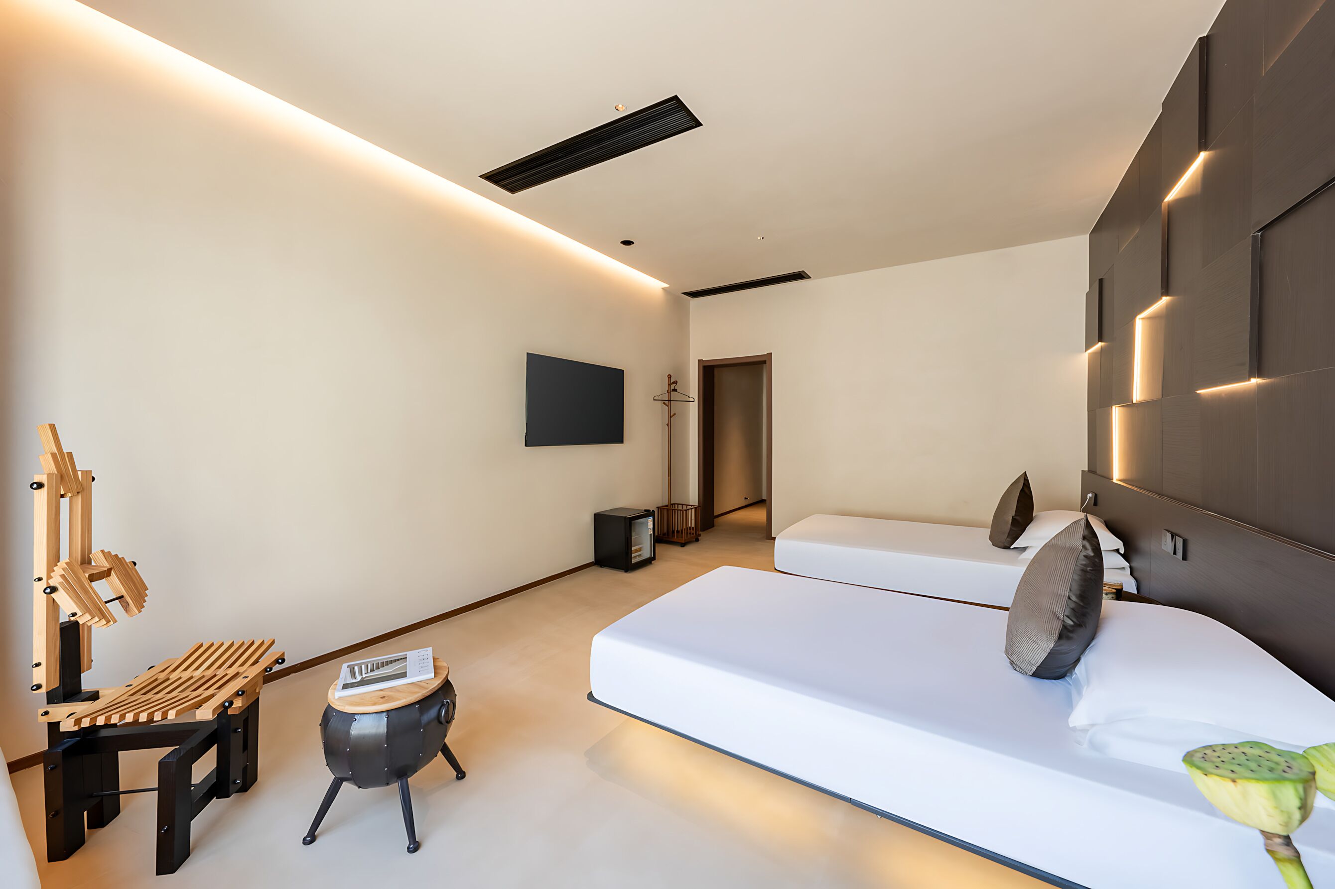A modern bedroom with a bed, bedside table, and a wall-mounted TV.