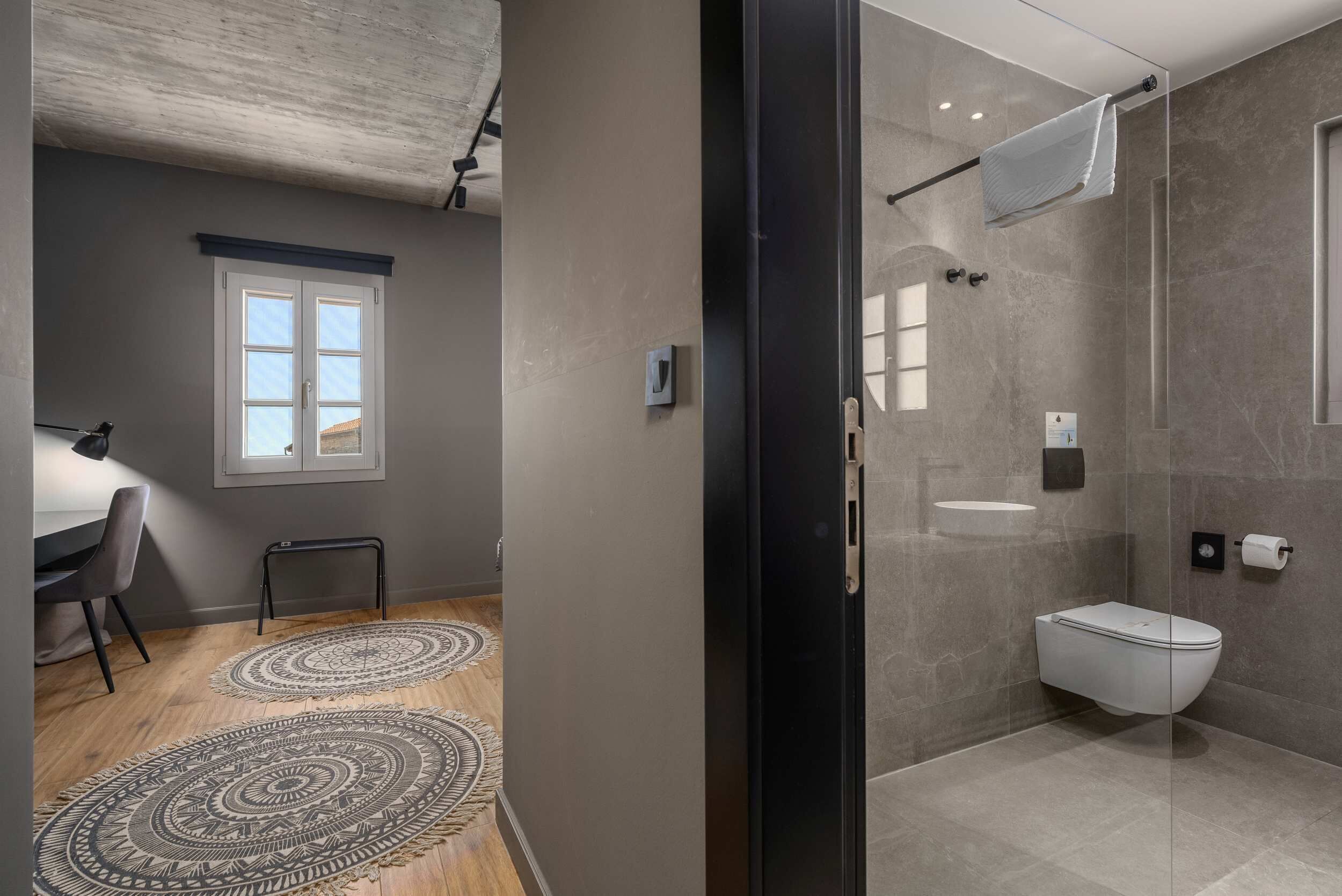 A modern bathroom with a glass shower enclosure, a toilet, and a sink.