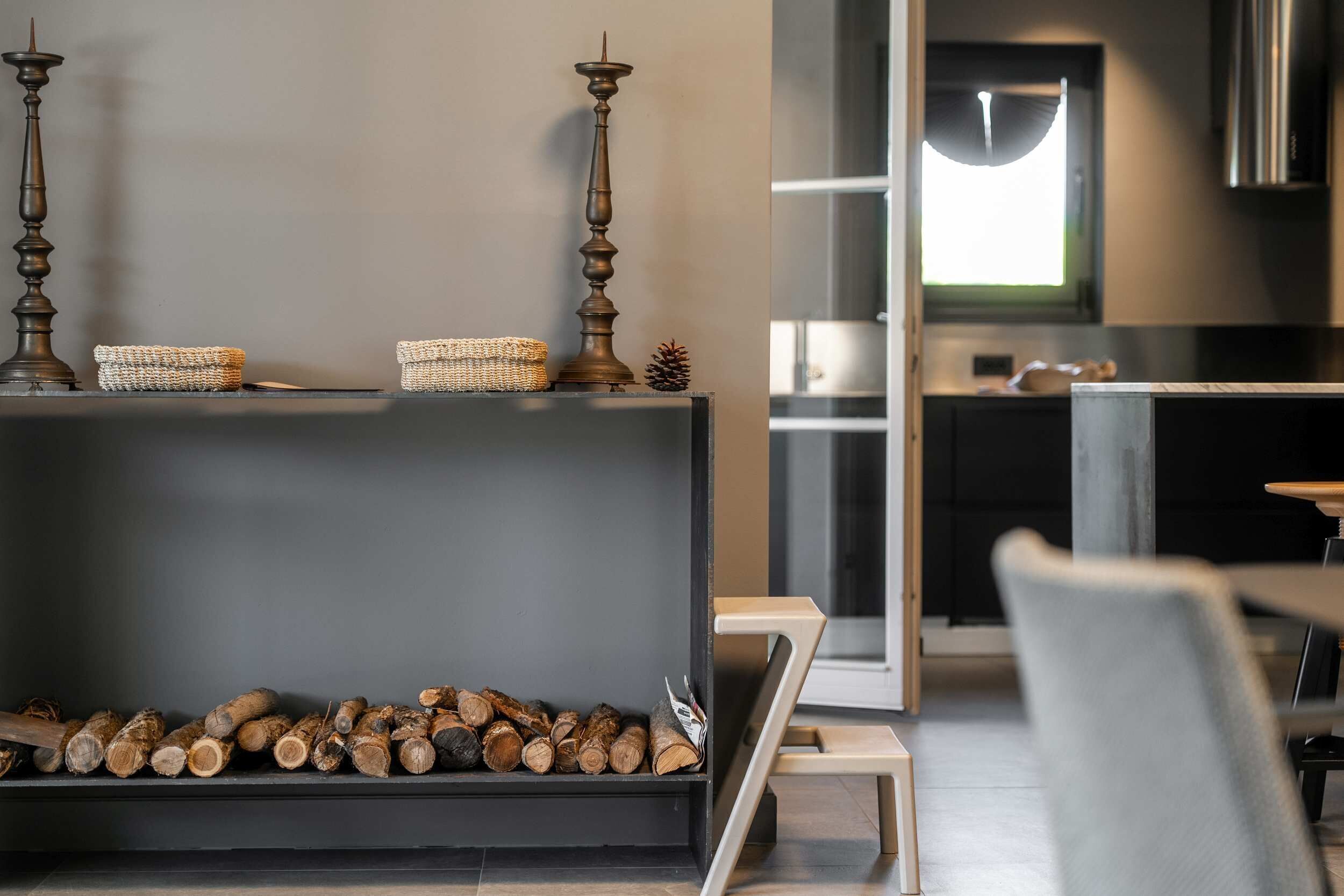Un interno moderno con un camino, un'area pranzo e una cucina sullo sfondo.