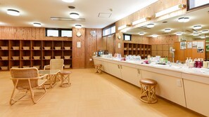 A room with wooden panel walls, a long counter with sinks, wicker chairs, and a mirror. - Hotel de Marronnier Gero Onsen (Gero)