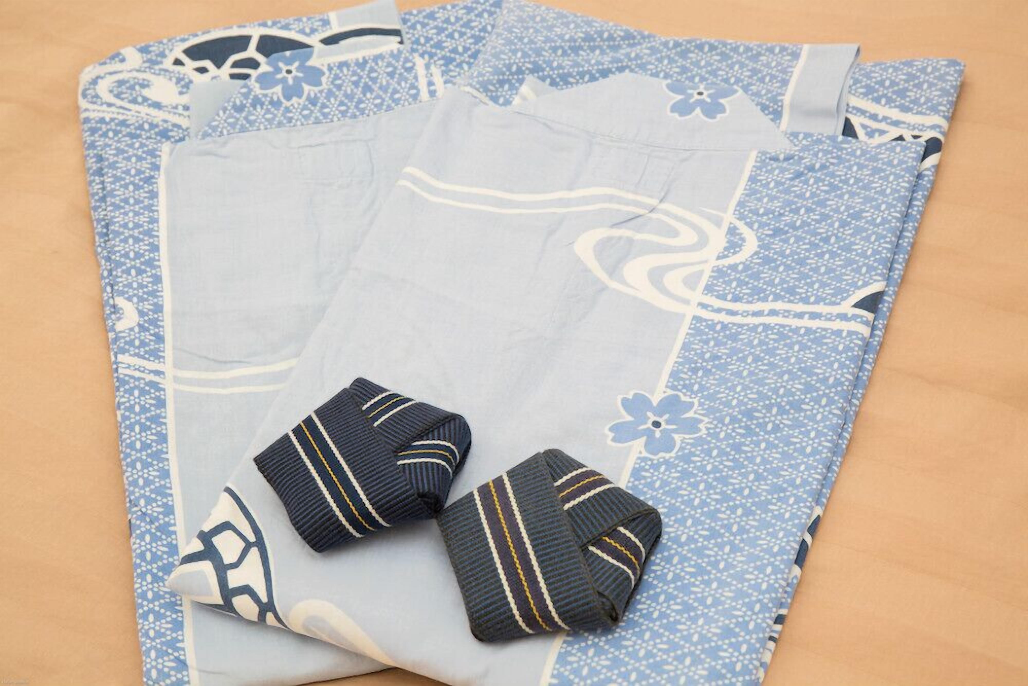 A neatly folded blue and white patterned fabric with two dark blue striped ties.