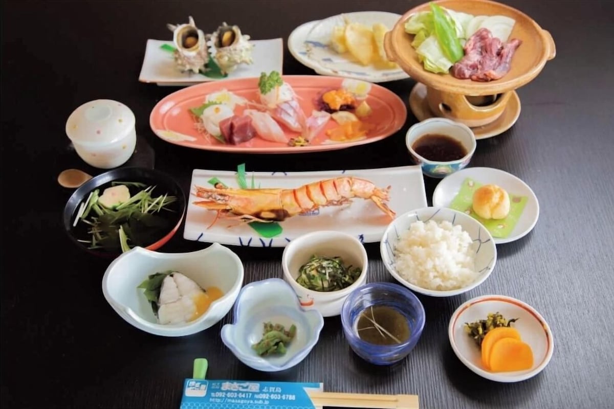 A variety of Japanese dishes including sushi, sashimi, and rice bowls, arranged on a table.