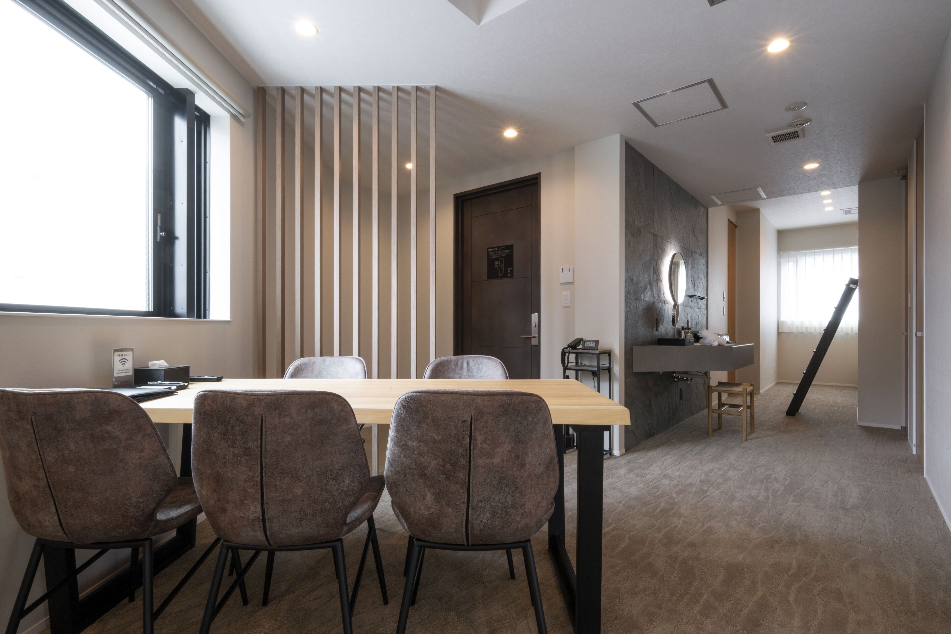 A modern interior with a dining area, a kitchen, and a bathroom.