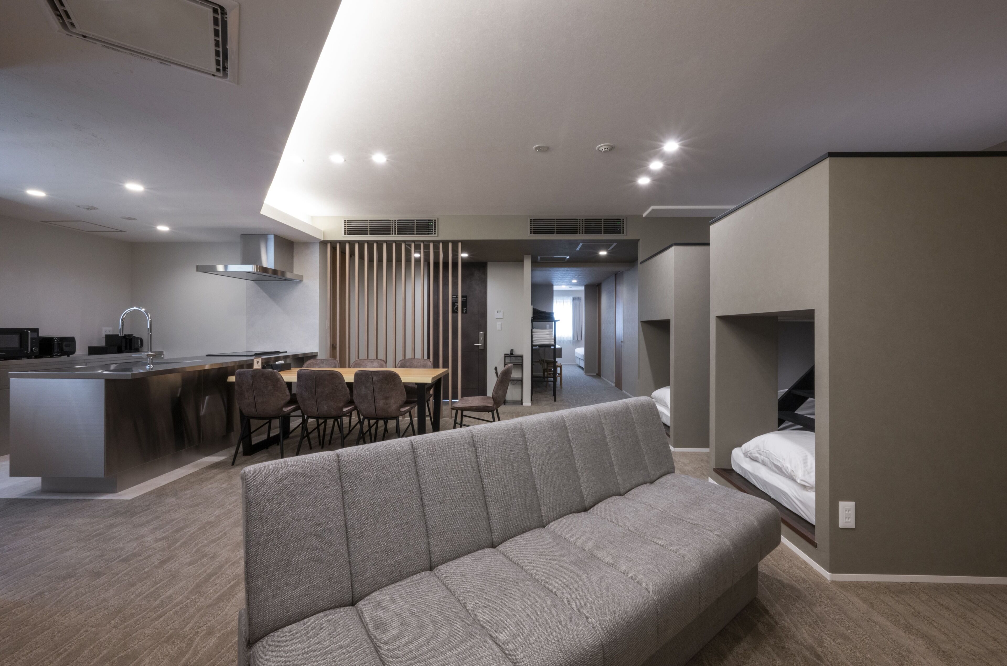 Un apartamento moderno con kitchenette, comedor y sofá.