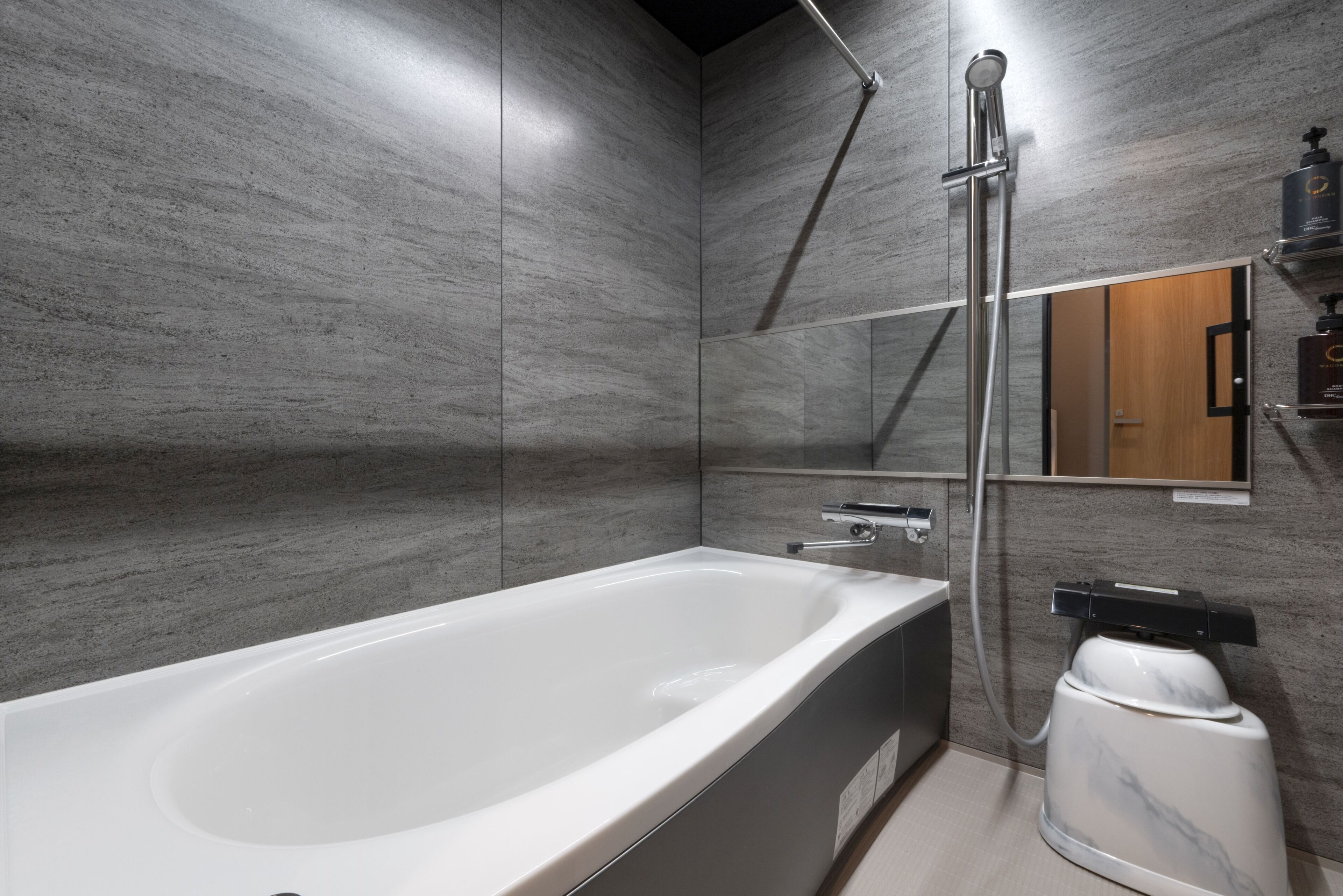 Un baño moderno con una bañera grande, una ducha y un espejo.