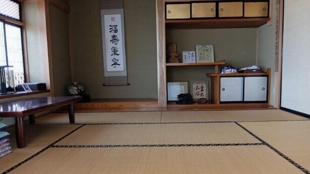 A tatami mat room with a low table, a shelf with storage boxes, and a hanging scroll on the wall. - Usa Usa no Petit Farm (Omachi)