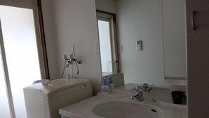 A bathroom with a sink, mirror, and a toilet. - Usa Usa no Petit Farm (Omachi)