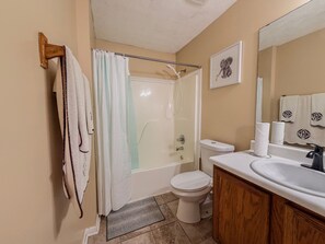 A bathroom with a shower, toilet, sink, and towel rack. - 3BR Atlanta Airport Home | Pet Friendly + Parking (Union City)