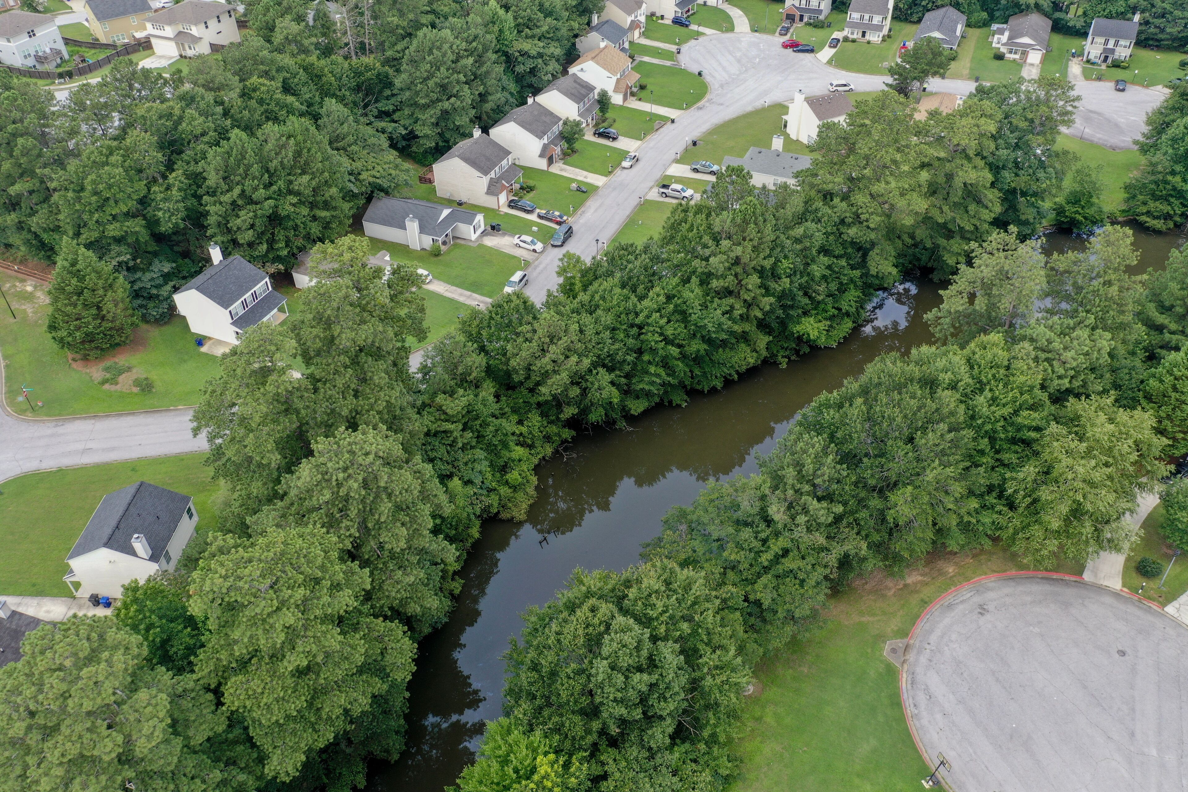 Vista aérea de una zona residencial con casas, un río y una glorieta.