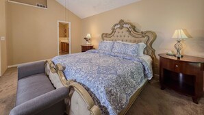 A bedroom with a bed, a ceiling fan, a nightstand with a lamp, and a bench. - 3BR Atlanta Airport Home | Pet Friendly + Parking (Union City)