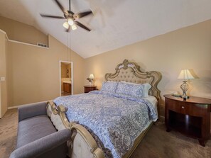 A bedroom with a bed, a ceiling fan, a nightstand with a lamp, and a bench. - 3BR Atlanta Airport Home | Pet Friendly + Parking (Union City)