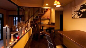 A modern interior with a wooden bench, a staircase, and a dining area.