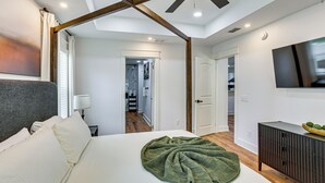 A bedroom with a bed, a green blanket, a wooden ceiling, a TV, and a cabinet. - Gateway to FSU & FAMU! Family-Friendly Retreat (Tallahassee)
