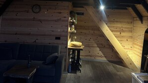 Interior acogedor de una cabaña con habitación en el altillo, comedor y sala de estar.