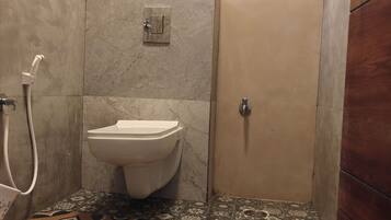 Baño con inodoro, ducha y espejo.
