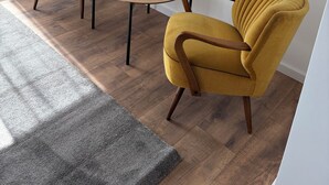 A room with two mustard-colored armchairs and a small round table with a candle. - Pollmann Vacation Home - Quietly Located with a View of the Countryside (Höxter)