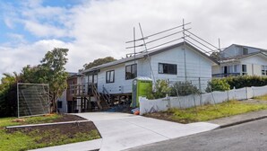 A residential house with a fenced yard, a small garden, and a portable toilet. - Sunny 3BDR Family Retreat in Leafy Glen Eden (Auckland)
