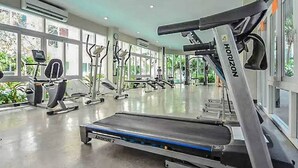 A gym with treadmills, ellipticals, and weight machines, large windows, and a clean, modern design. - Heaven of PATTAYA!!! (Muang Pattaya)