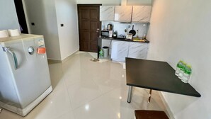 A compact kitchen with a refrigerator, a microwave, a sink, and a small dining table. - Heaven of PATTAYA!!! (Muang Pattaya)
