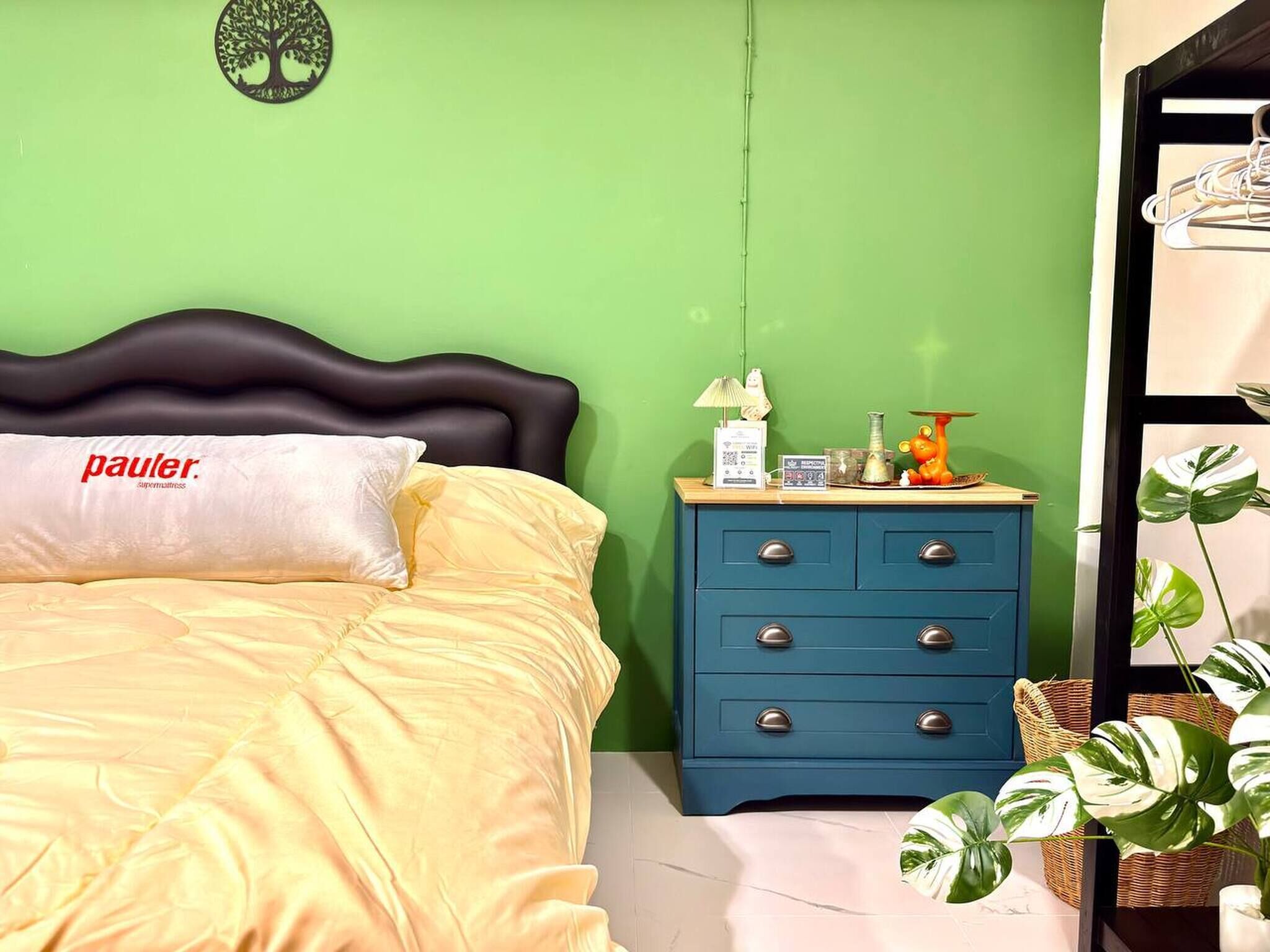 Ein Schlafzimmer mit Bett, Nachttisch, Lampe und Wanddekoration.