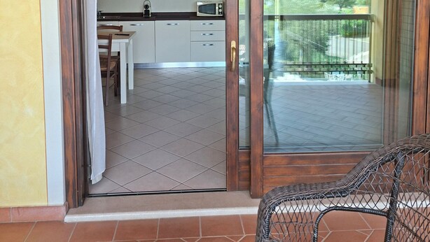 Une cuisine avec des meubles blancs, un four à micro-ondes et un coin repas comprenant une table et des chaises.