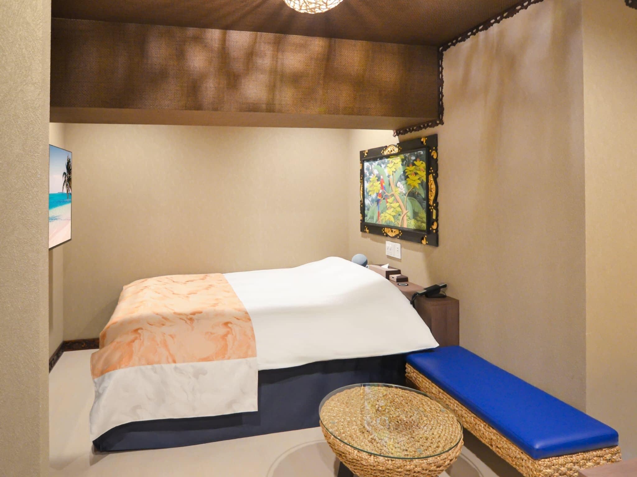 A bedroom with a bed, a bedside table, a wall-mounted TV, and a woven basket.