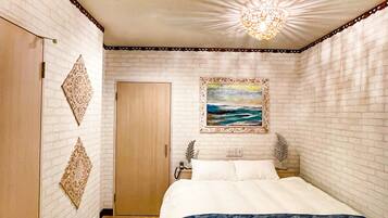 A bedroom with a bed, a painting, a wooden wardrobe, and a decorative ceiling light.