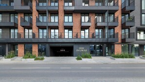 A multi-story building with a modern design, featuring a prominent entrance with a glass facade and a sign reading 'BVLWAR'. - Beige Apartment By the River | 2 Balconies (Szczecin)