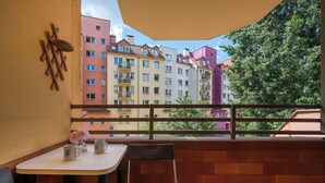 Ein Balkon mit Tisch, Stuhl und Dekoration.