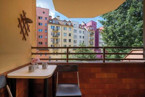 A balcony with a table, chair, and decorative items. - Spacious Apartment in Center | Balcony | Desk (Wrocław)