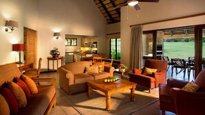 Un amplio salón con techo alto, comedor y vistas a un campo de golf.