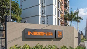 A modern multi-story building with a sign reading 'INSIGNIA 04' and air conditioning units on the exterior. - Corporate Stays Insignia 4 - A51 (Lúke)