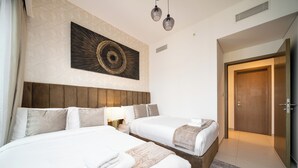 A hotel room with two beds, a wooden headboard, a wall-mounted artwork, a bedside lamp, and a door leading to another room. - Luxury 3.5BR Burj Khalifa LED View  (Dubai)
