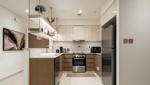 A modern kitchen with stainless steel appliances, wooden cabinetry, and a central island. - Luxury 3.5BR Burj Khalifa LED View  (Dubai)
