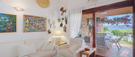 Una sala de estar con un sofá, una mesa y vistas al exterior.
