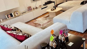 Un salon moderne comprenant deux canapés, un téléviseur à écran plat, une table basse et une petite table d’appoint.